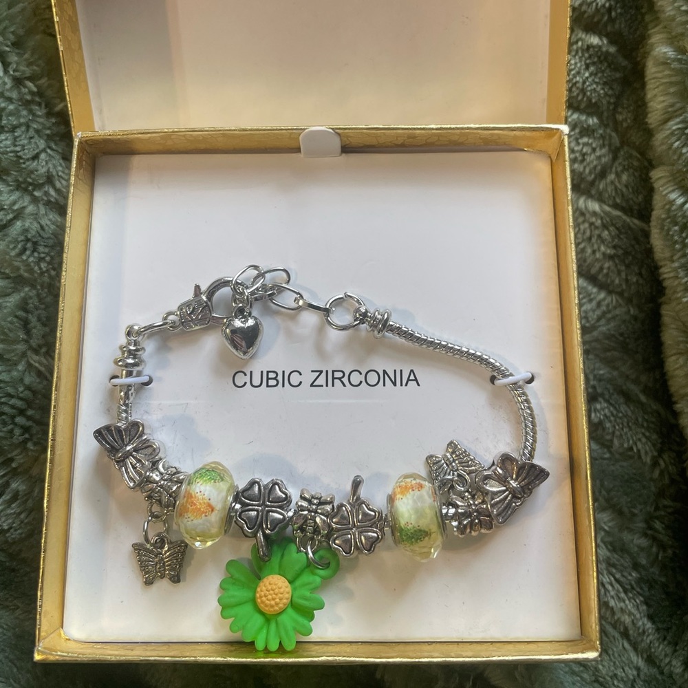 Charm bracelet with flowers, four leaf clovers, and butterflies